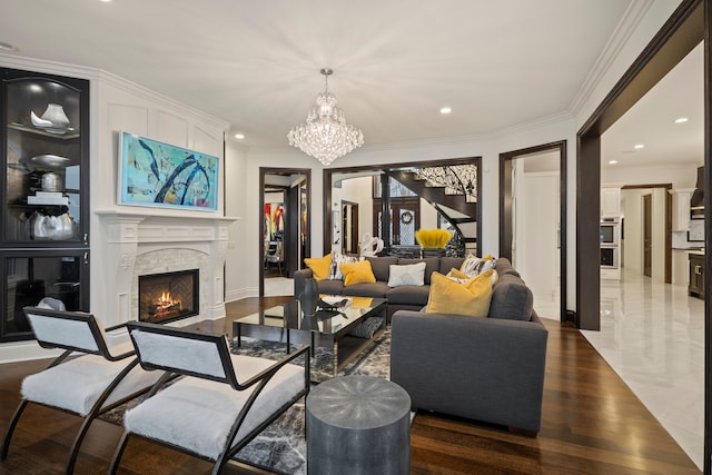 living room featuring a warm lit fireplace, ornamental molding, a chandelier, and recessed lighting