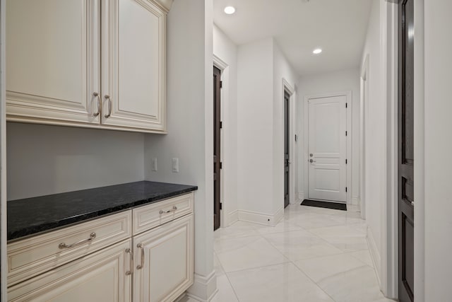 hallway featuring baseboards and recessed lighting