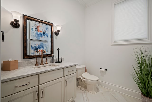 half bath with toilet, baseboards, crown molding, and vanity