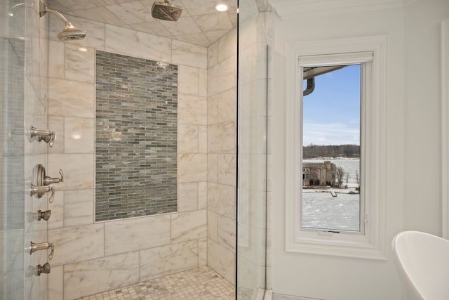 full bathroom with crown molding, a freestanding tub, and a tile shower