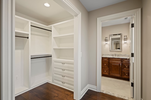 walk in closet featuring visible vents, dark wood finished floors, and a sink