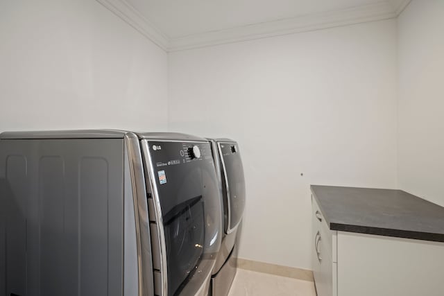 washroom with light tile patterned flooring, baseboards, independent washer and dryer, cabinet space, and crown molding