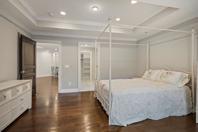 bedroom with crown molding, a raised ceiling, dark wood-type flooring, and recessed lighting