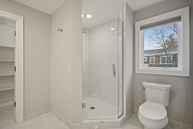 full bathroom with toilet, a shower stall, and baseboards