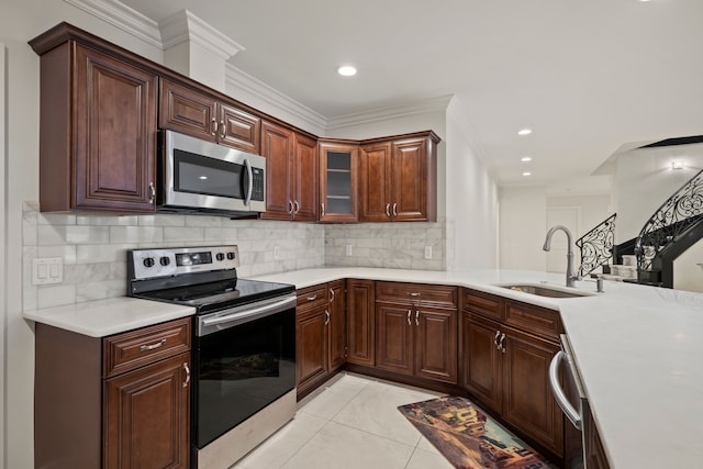 kitchen featuring appliances with stainless steel finishes, light countertops, light tile patterned flooring, and a sink