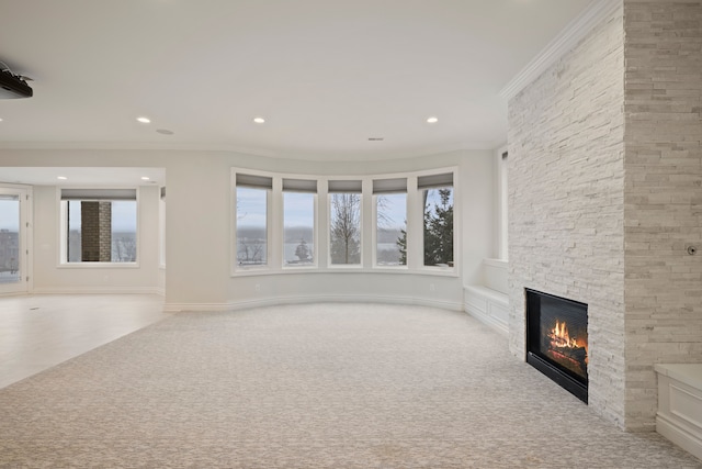 unfurnished living room featuring carpet, crown molding, a fireplace, recessed lighting, and baseboards