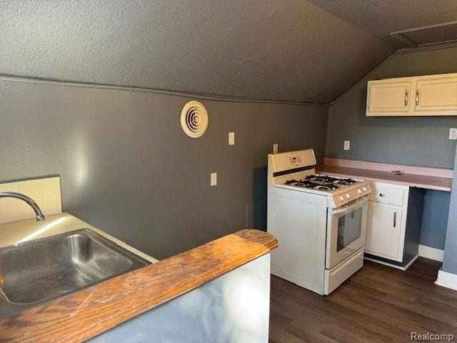 kitchen with white cabinets, a sink, gas range gas stove, and a textured ceiling