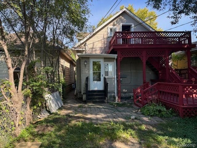 back of house featuring entry steps and a wooden deck