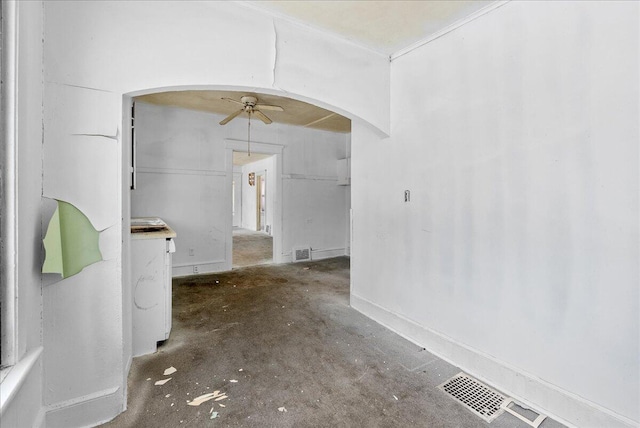 unfurnished dining area featuring arched walkways, ceiling fan, visible vents, and concrete flooring