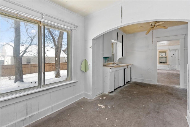 kitchen with a sink, arched walkways, and a ceiling fan