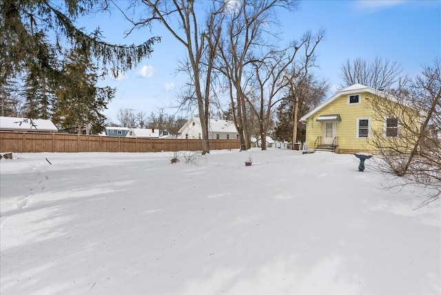 yard covered in snow with fence