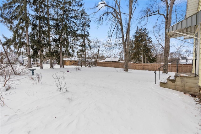 yard covered in snow featuring fence