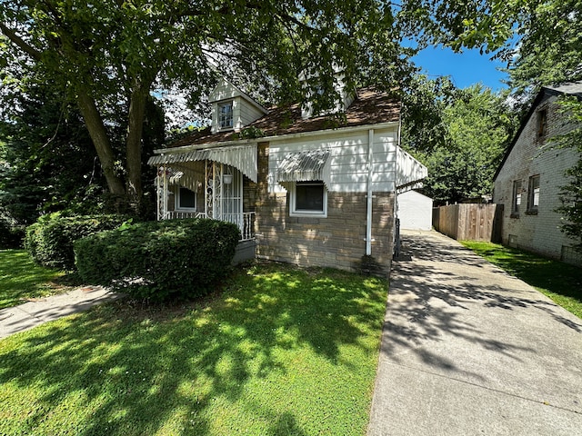 view of front facade featuring stone siding, a front yard, and fence