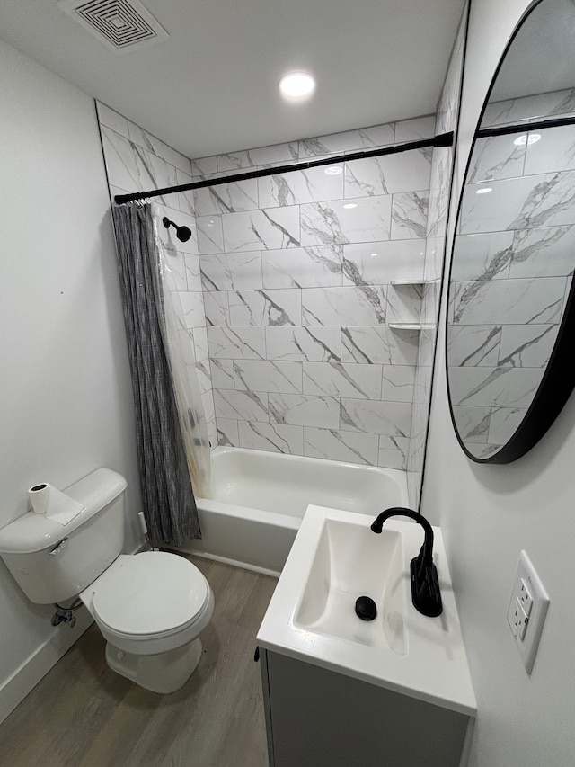 full bathroom with visible vents, toilet, shower / tub combo with curtain, wood finished floors, and vanity