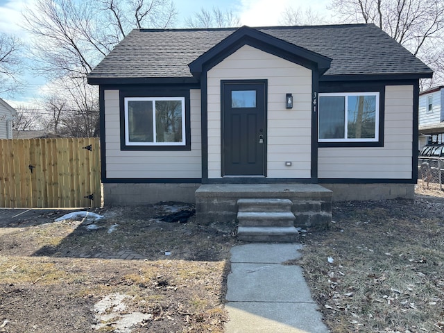 bungalow with roof with shingles and fence