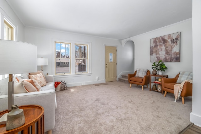 living area with ornamental molding, arched walkways, stairway, and carpet floors