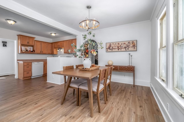 dining space with baseboards, a chandelier, light wood-style flooring, and a healthy amount of sunlight