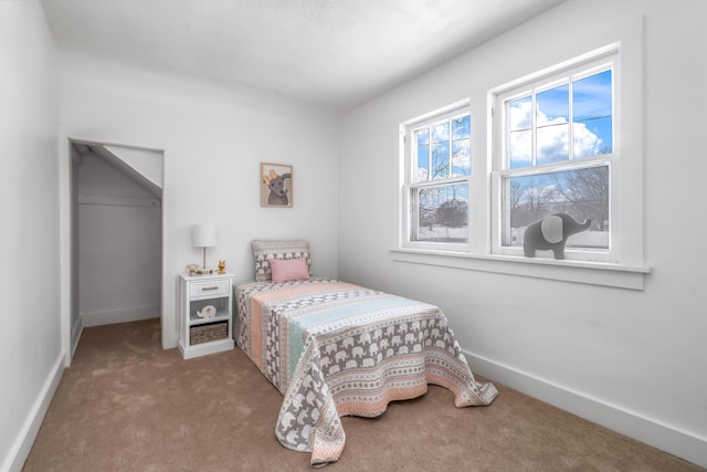 carpeted bedroom with a closet and baseboards