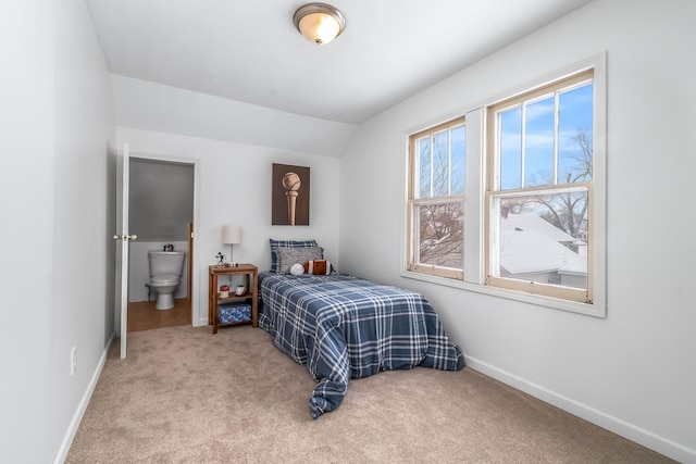 bedroom with connected bathroom, baseboards, vaulted ceiling, and carpet flooring