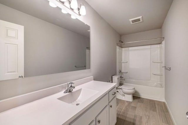 bathroom with visible vents, toilet, wood finished floors, vanity, and washtub / shower combination