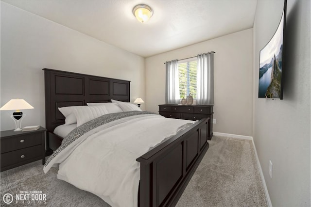 bedroom with baseboards and light colored carpet