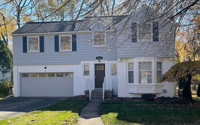 view of front of property with a garage, brick siding, driveway, roof with shingles, and a front lawn