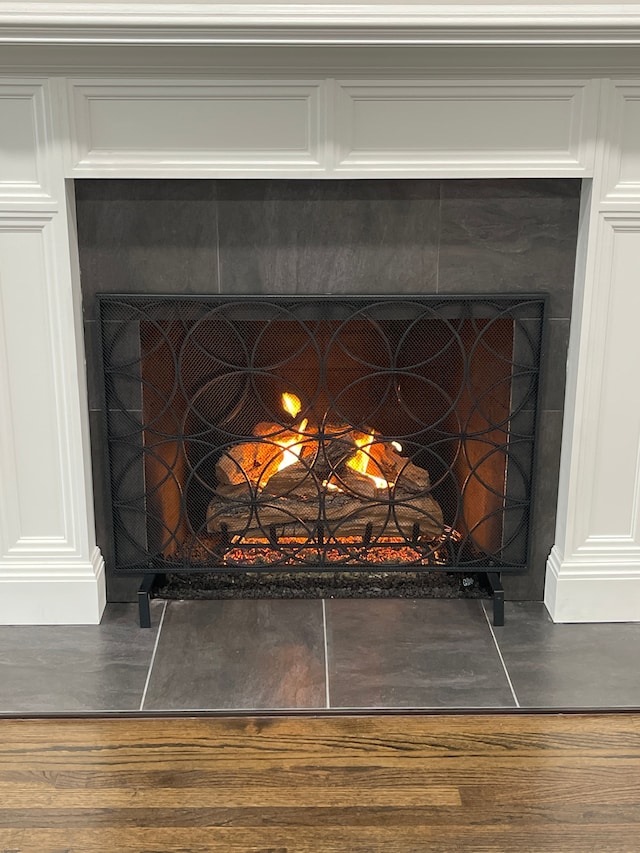 details with a fireplace and wood finished floors