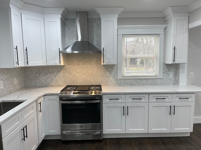 kitchen with wall chimney exhaust hood, white cabinetry, and stainless steel gas range oven