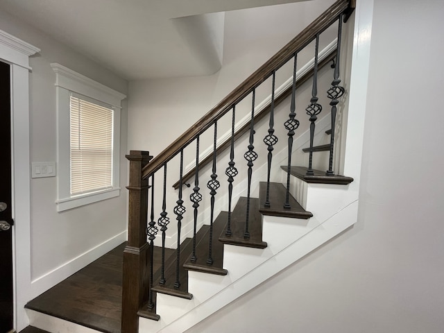 stairs with wood finished floors and baseboards