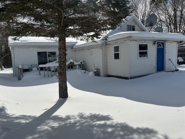 view of snow covered back of property