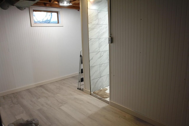 basement featuring light wood-style flooring and baseboards