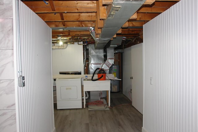 unfinished basement featuring water heater, washer / clothes dryer, and wood finished floors