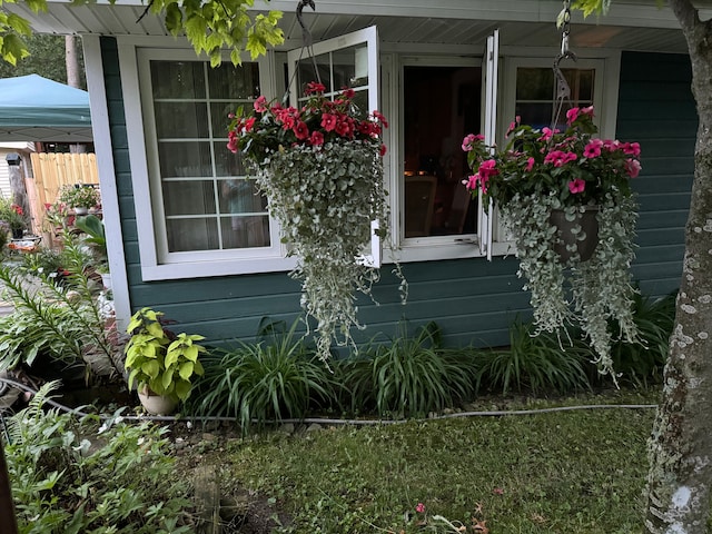 view of home's exterior with covered porch and fence