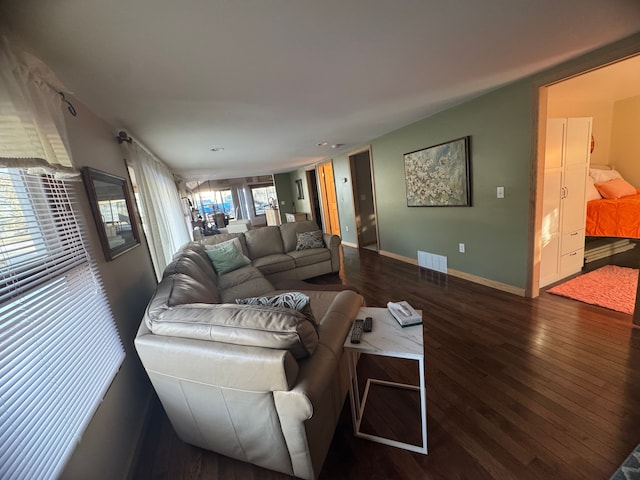 living area with visible vents, baseboards, and wood finished floors