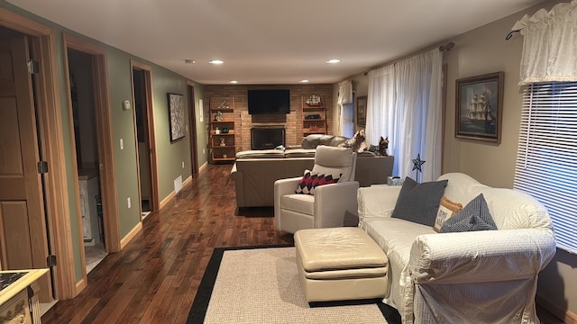 living room featuring recessed lighting, baseboards, dark wood finished floors, and a fireplace