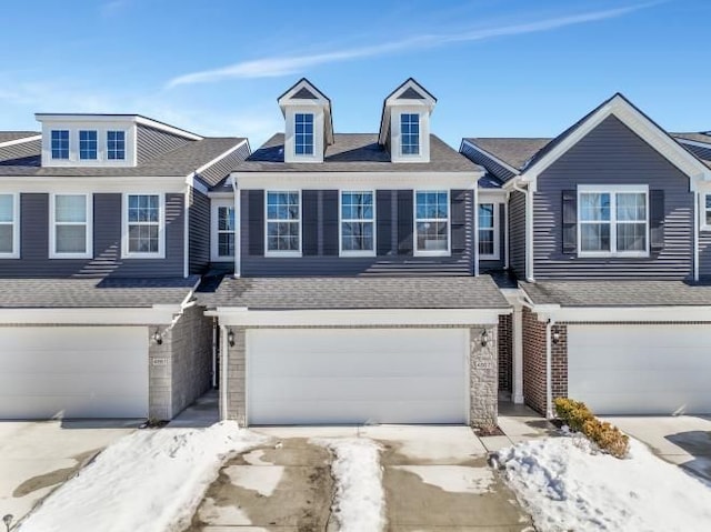 multi unit property featuring a garage and a shingled roof