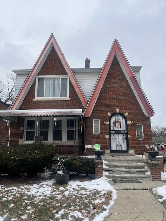 tudor house with brick siding and a chimney