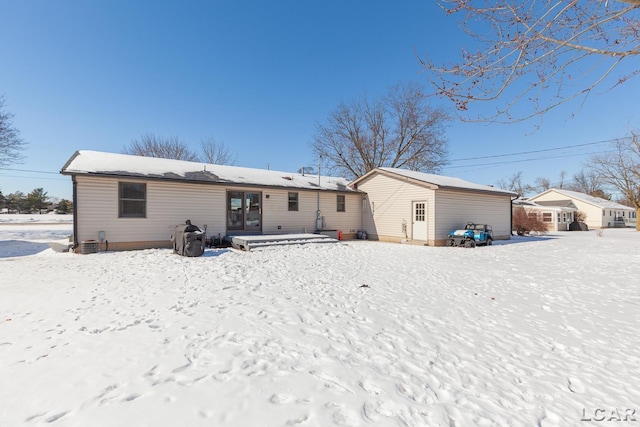 snow covered back of property with cooling unit