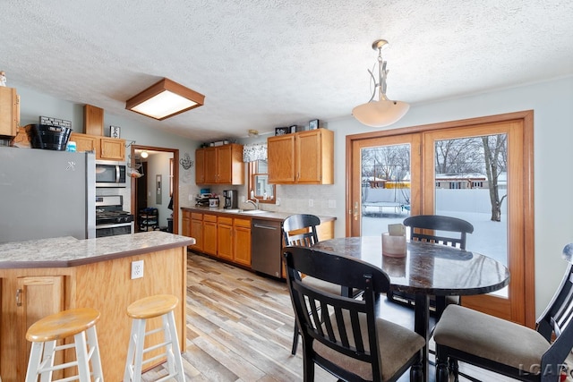 kitchen with light countertops, appliances with stainless steel finishes, a sink, and a healthy amount of sunlight