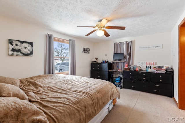 bedroom featuring light carpet, ceiling fan, and a textured ceiling