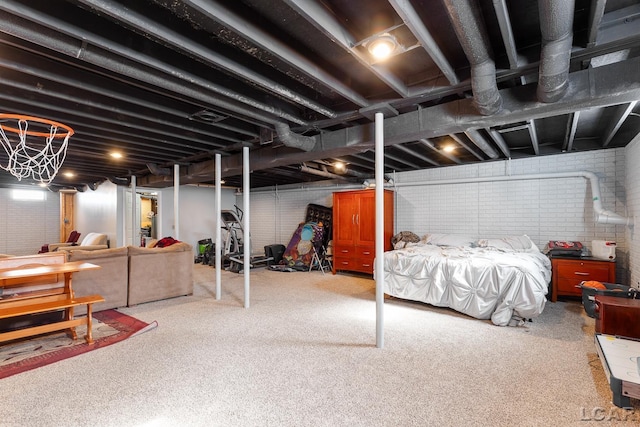 unfinished basement featuring brick wall and carpet flooring