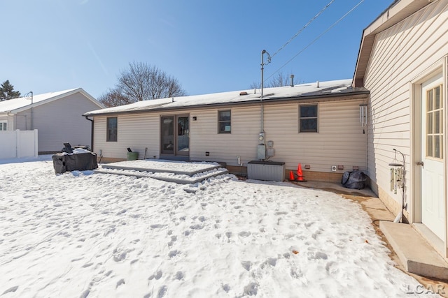 view of snow covered back of property