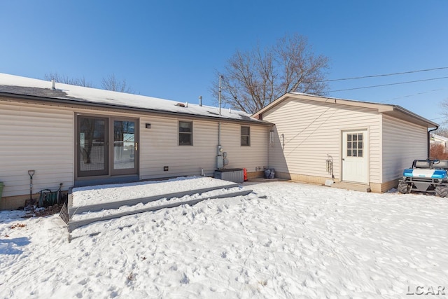 view of snow covered rear of property