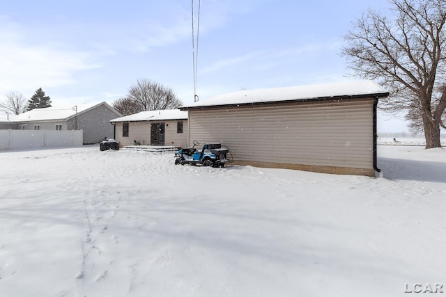 view of snow covered back of property