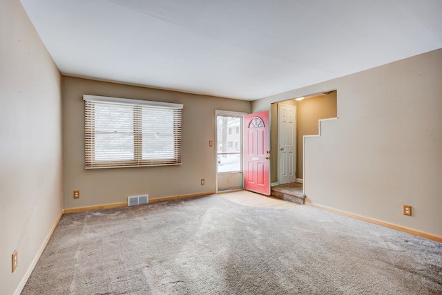 unfurnished room featuring baseboards, visible vents, and light colored carpet