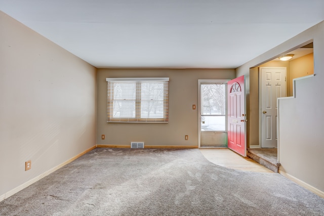 unfurnished room featuring light carpet, baseboards, and visible vents