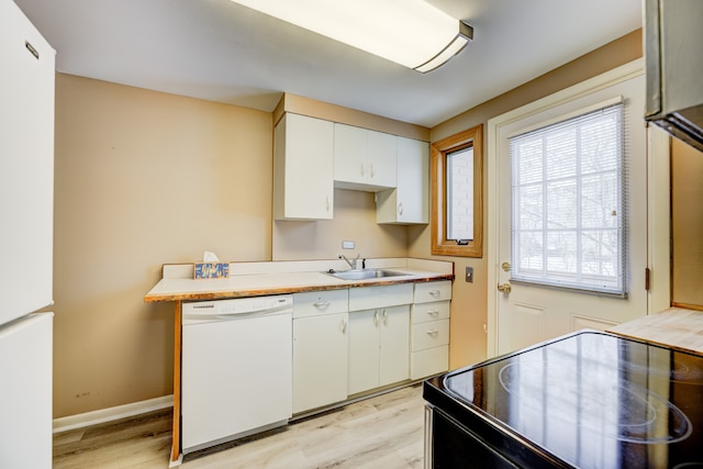 kitchen featuring white cabinets, white appliances, light countertops, and a sink