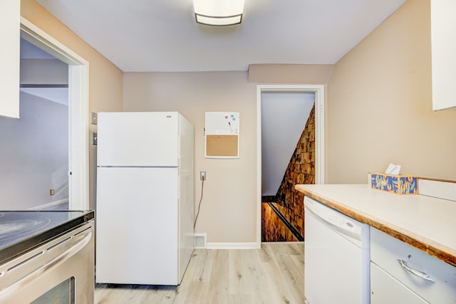 kitchen with white appliances, light wood finished floors, visible vents, white cabinets, and light countertops