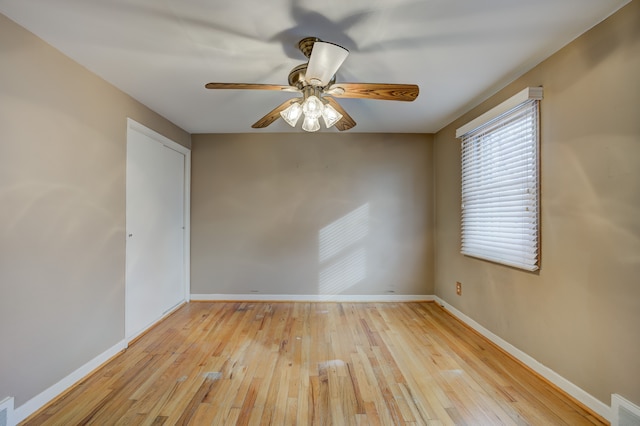 unfurnished room featuring a ceiling fan, baseboards, visible vents, and light wood finished floors