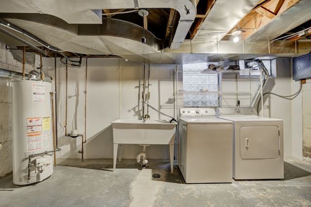 interior space featuring water heater, a sink, and washing machine and clothes dryer